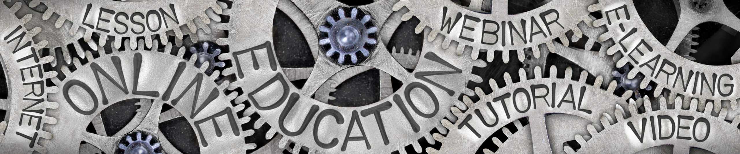 Photo Of Metal Wheel Group With Online Education, Webinar, Internet, Tutorial And E-Learning Concept Related Words Imprinted On Metal Surface.